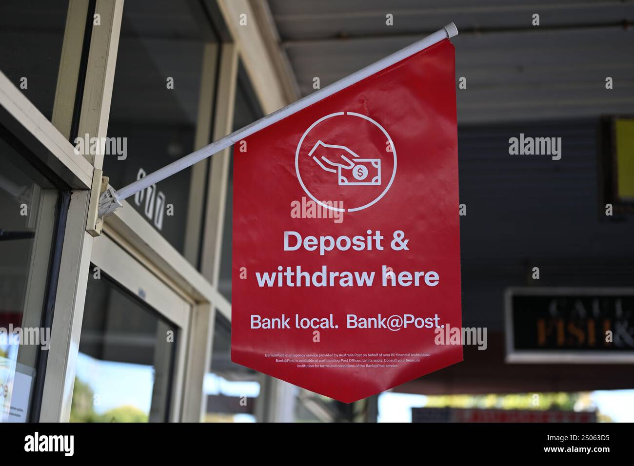 Rouge et blanc Bank at Post signe suspendu à l'extérieur d'un magasin de poste australien, informant les clients qu'ils peuvent déposer et retirer de l'argent ici Banque D'Images