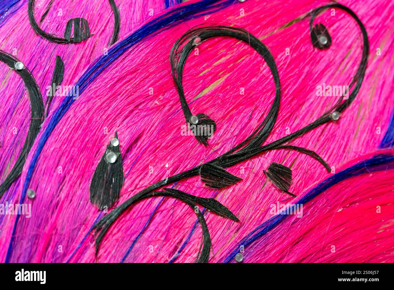 L'œuvre d'art colorée présente un fond rose audacieux orné de motifs noirs fluides et d'embellissements délicats, créant un contraste visuel saisissant. Banque D'Images