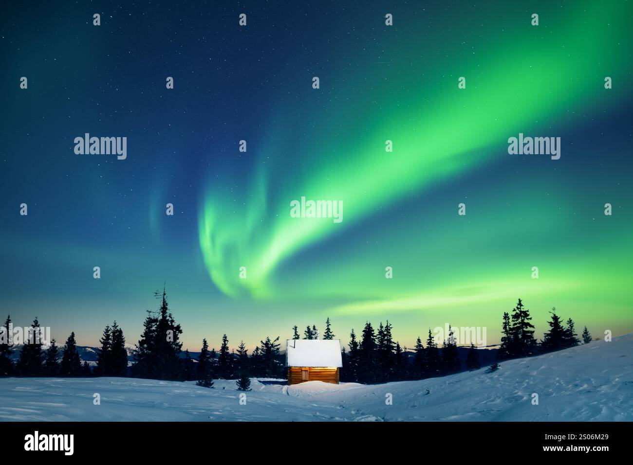 Incroyables aurores boréales sur une petite maison en bois dans les montagnes enneigées. Vacances de Noël et vacances d'hiver concept. Aurora Borealis. Lumières polaires Banque D'Images