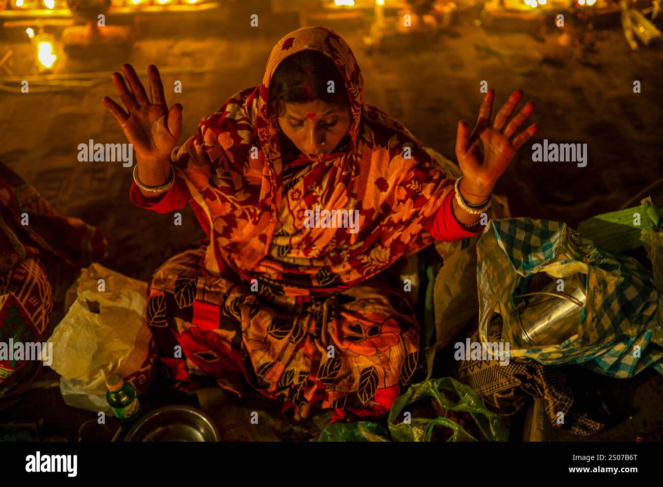 Les dévots s'assoient dans la prière avec de l'encens brûlants et des lampes à huile brillantes pendant Rakher Upobash, un festival de jeûne sacré, à l'Ashram i de Lokenath Brahmachari Banque D'Images