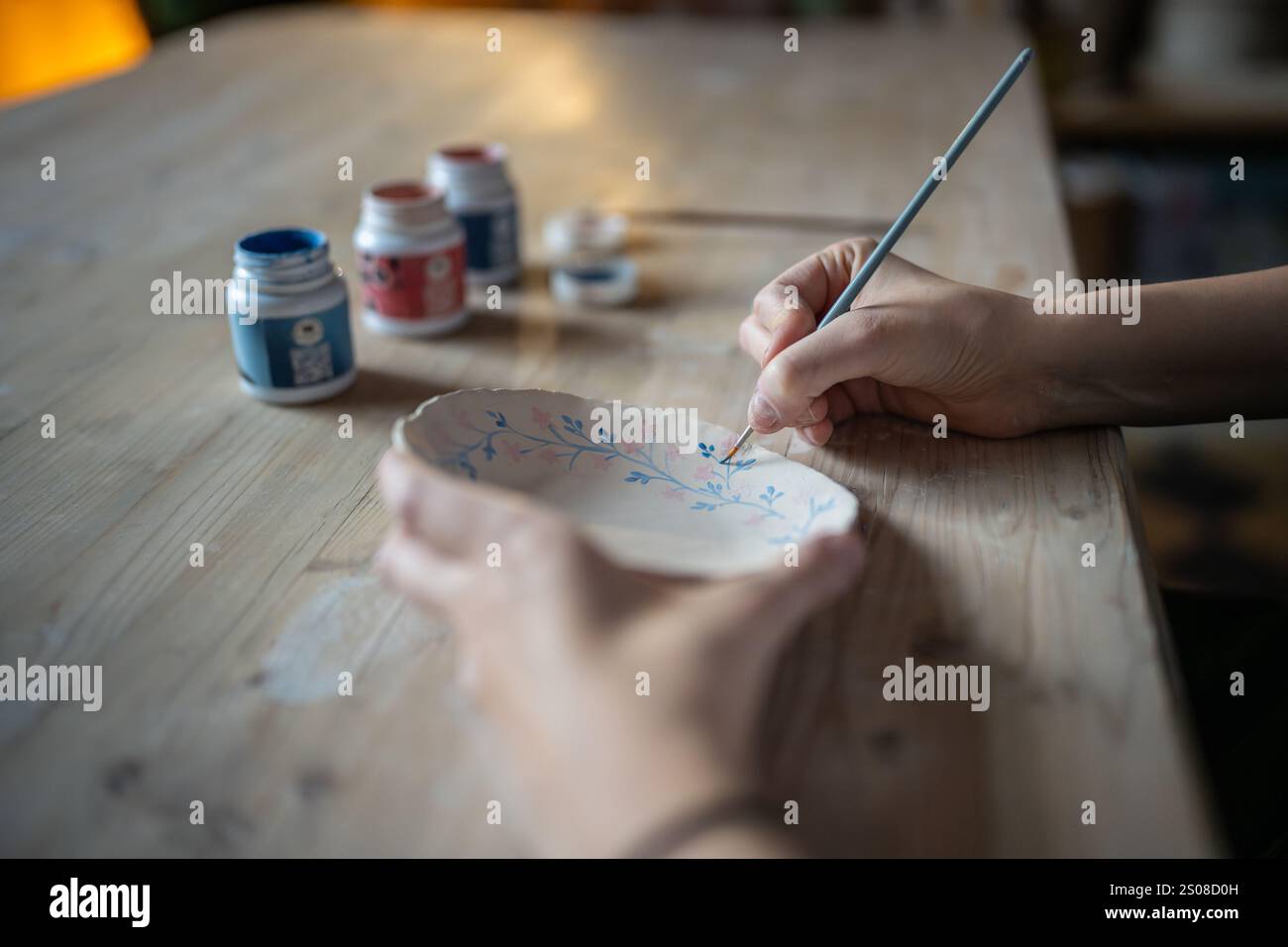 Soucoupe en céramique peinte avec des acryliques par artiste en studio, fabriquée à la vente. Poterie artisanale Banque D'Images