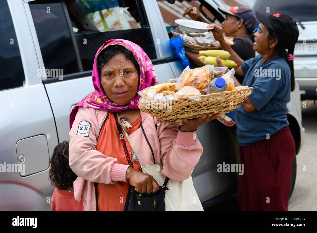 Redjang, Flores, Indonésie - 1er novembre 2024 : vendeurs de rue vendant des collations aux voitures en attente. Banque D'Images