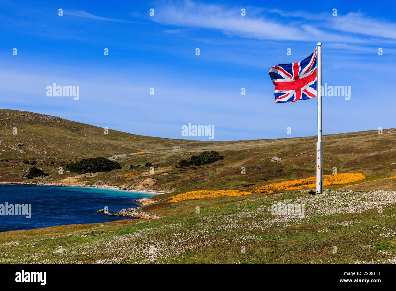 l'union jack vole sur un mât surplombant l'eau calme de la jetée d'atterrissage pour west point island pour visiter les colonies de pingouins et d'albatros Banque D'Images