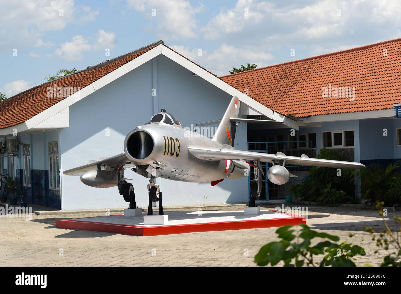 Un chasseur Mikoyan-Gurevich MiG-17 de l'armée de l'air indonésienne conservé comme monument dans la cour avant d'une école primaire Banque D'Images