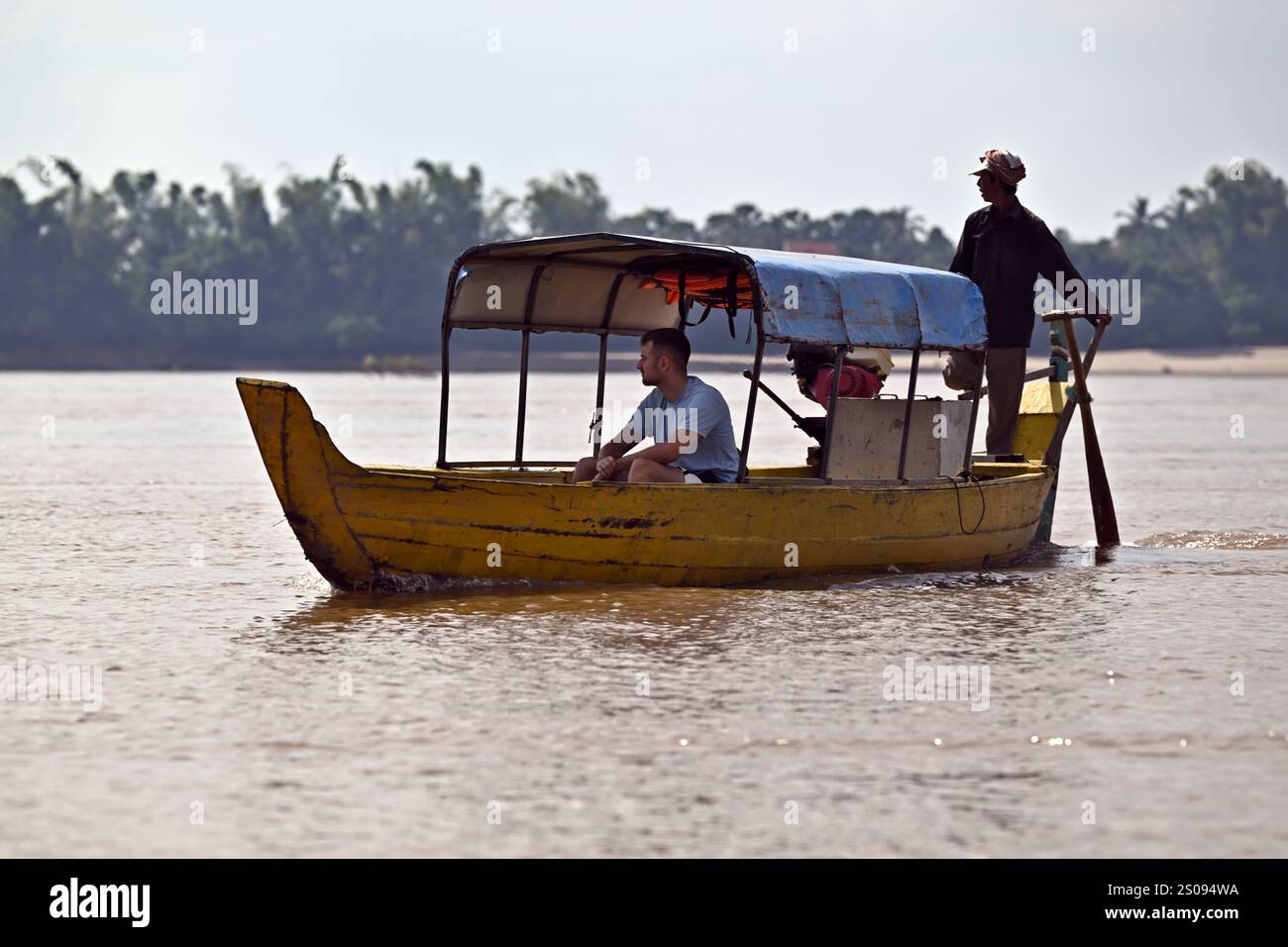 Un touriste tente de repérer les dauphins d'Irrawaddy sur le fleuve Mékong à Kratie, au Cambodge. Banque D'Images