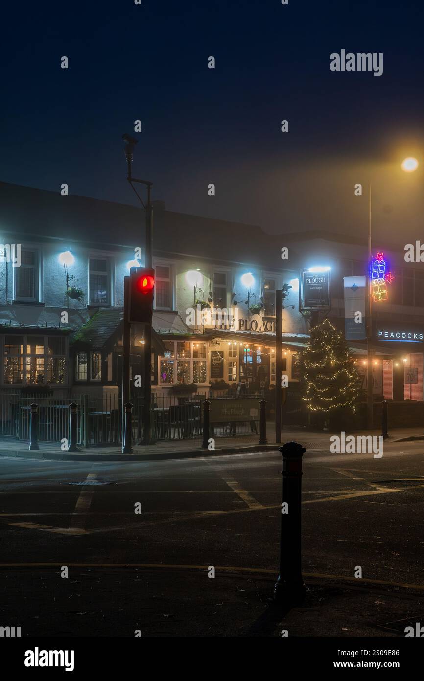 The Plough public House un jour d'hiver brumeux la veille de Noël 2024. Froid. Bienvenue. Lampes. Brume. Brouillard. Saisonnier. Feu rouge. Banque D'Images