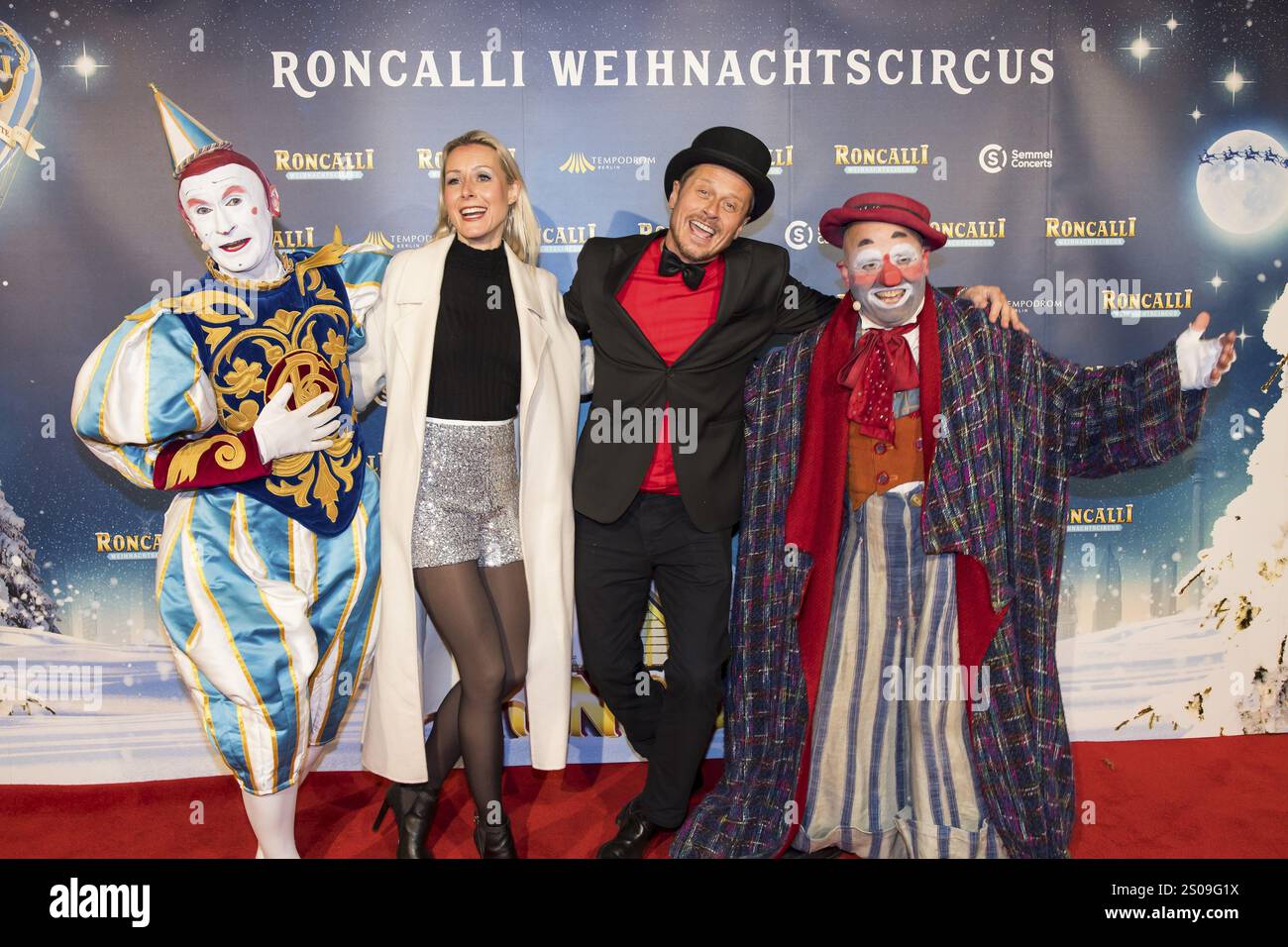 Franziska Hippe et Roman Knizka entre les deux clowns Gensi et Oriol lors de la première du 20e Roncalli Weihnachtscircus original au TEM de Berlin Banque D'Images