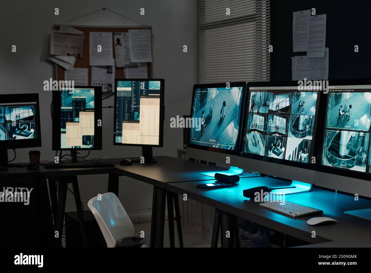 Rangée de moniteurs d'ordinateur de bureau avec enregistrements de caméras vidéo cctv sur des écrans debout sur les lieux de travail des agents de surveillance Banque D'Images