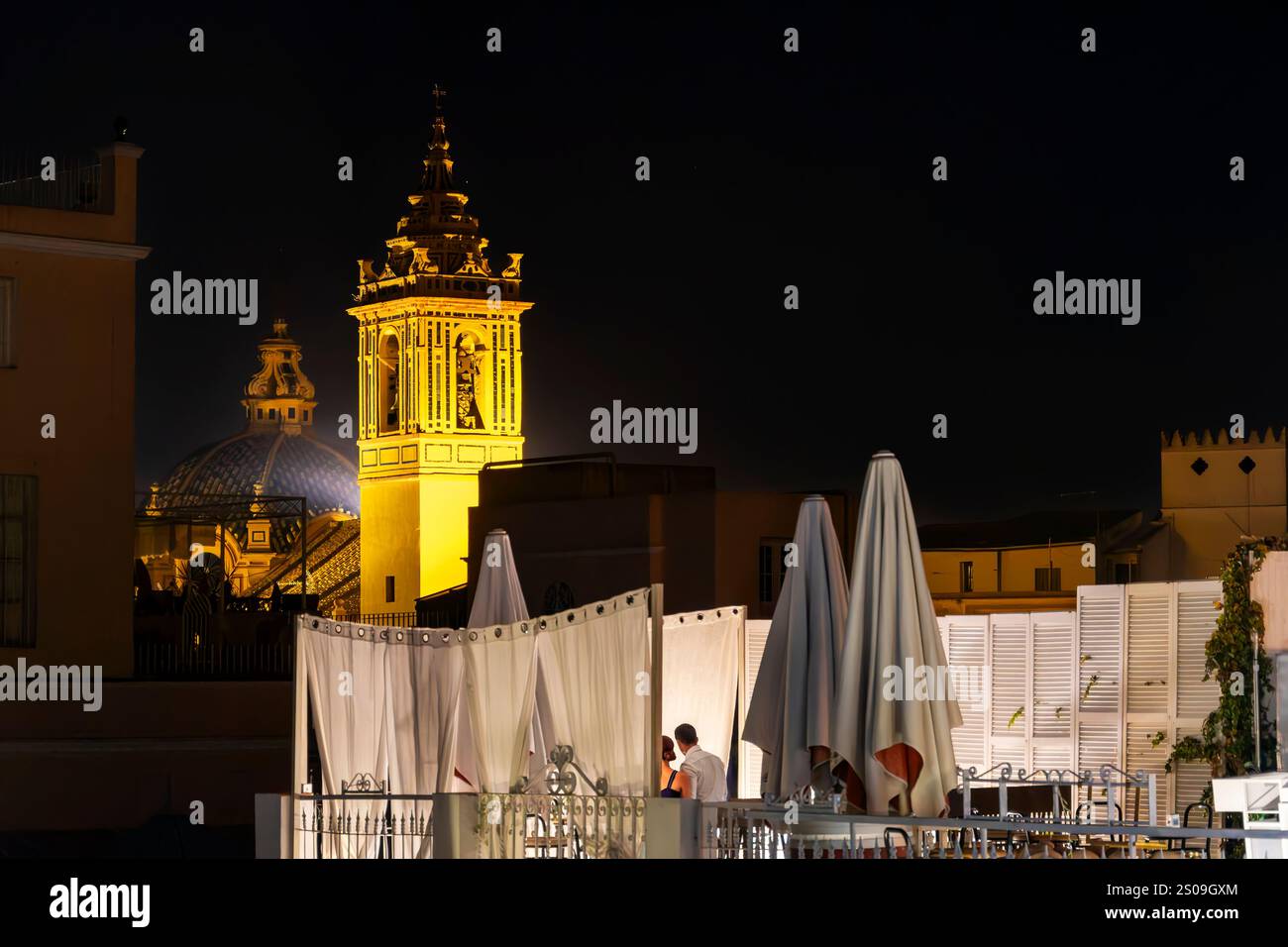 Un cocktail sur le toit et dôme illuminé et clocher de l'église des membres Albert et de Philip Neri dans le quartier Santa Cruz de Séville, Espagne. Banque D'Images