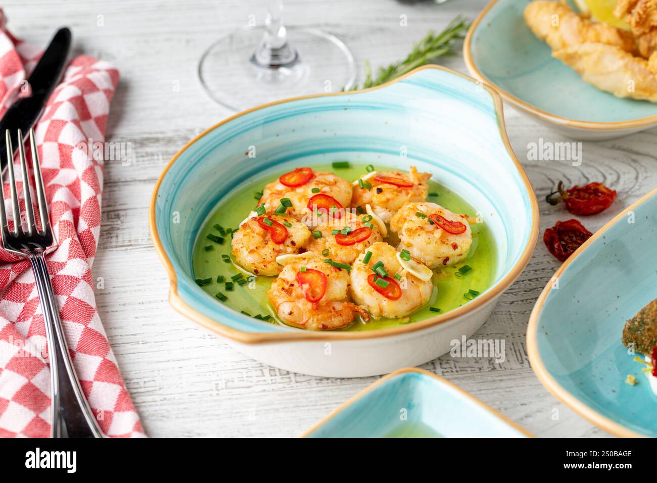 Apéritif avec des crevettes, des oignons et des tomates sur une assiette en porcelaine blanche Banque D'Images