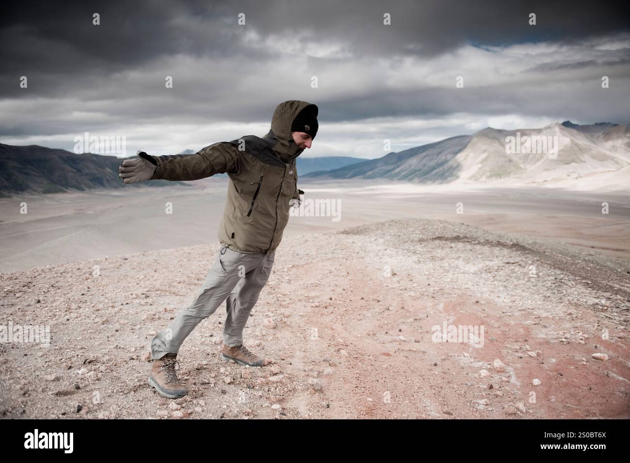 Un alpiniste se penche dans un vent fort dans la vallée de dix mille fumées, parc national de Katmai, Alaska. Banque D'Images