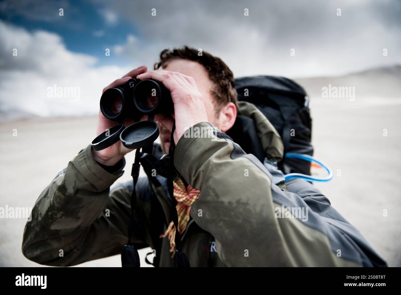 Un alpiniste scrute l'horizon pour trouver des ours bruns avec ses jumelles, Valley of Ten Thousand Smokes, katmai National Park, Alaska. Banque D'Images