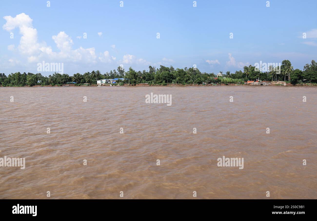 Delta du Mékong, Vietnam. 27 décembre 2024 : les rives du Mékong s’érodent. Sur la gauche, les murs d'une maison se sont effondrés dans la rivière. L’extraction de sable et de gravier (mines ou dragues) utilisée pour l’industrie de la construction soulève des avertissements sur l’impact environnemental de la surexploitation des sédiments du lit fluvial (biodiversité et écosystème), mais aussi sur la vie des personnes vivant sur les berges. L'exploitation légale ou illégale du sable entraîne une érosion massive des berges, entraînant la perte de terres agricoles, l'effondrement de bâtiments ou de maisons et la réinstallation de populations. Crédit : KEVIN IZORCE/Alamy Live News Banque D'Images
