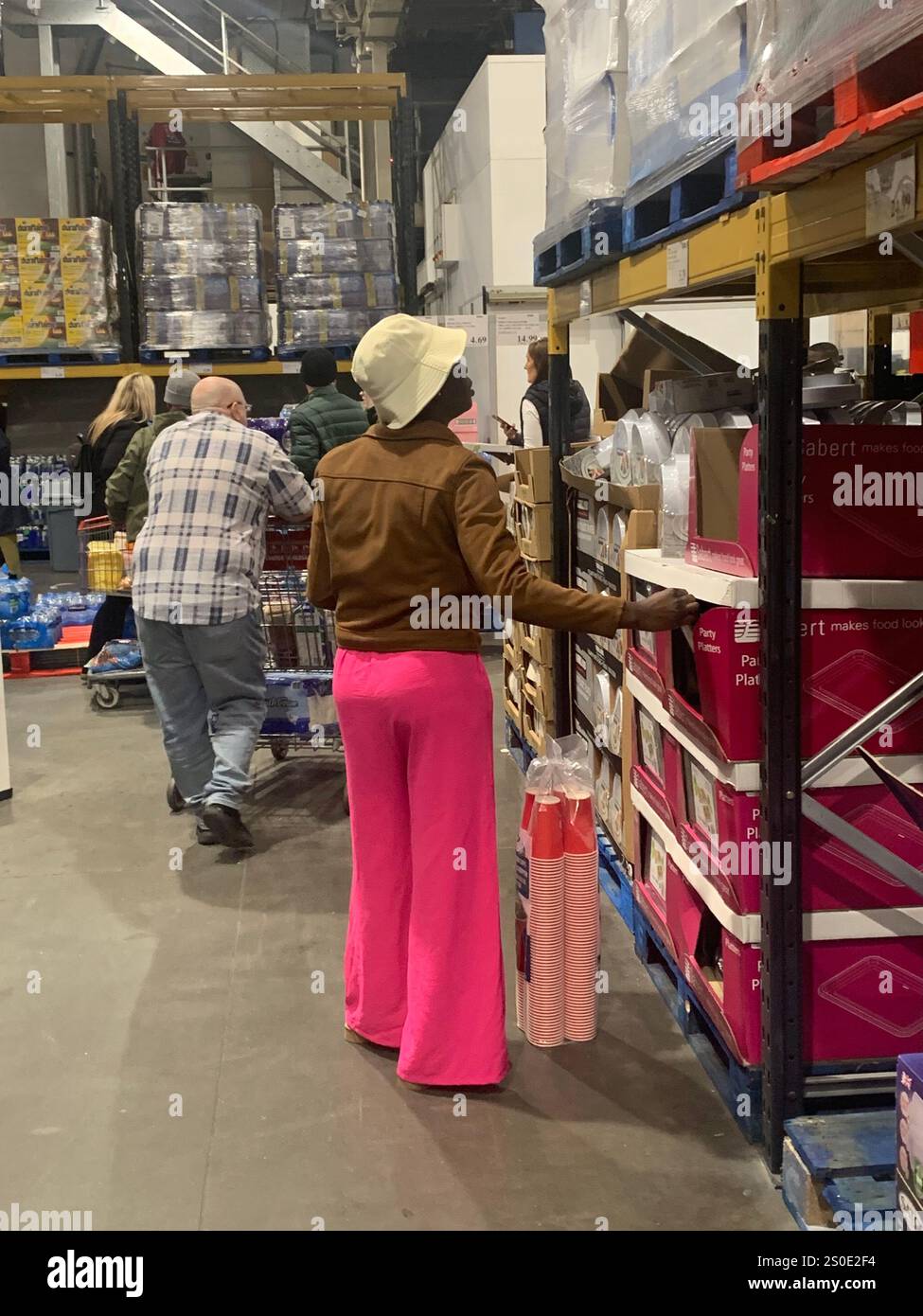 Costco Leeds magasin lieu de shopping personne pantalon rose shoppers dame acheter jusqu'à ce que les tills lumières lumineux clients Angleterre Yorkshire argent liquide vêtements nourriture - Image de stock capturée avec un smartphone