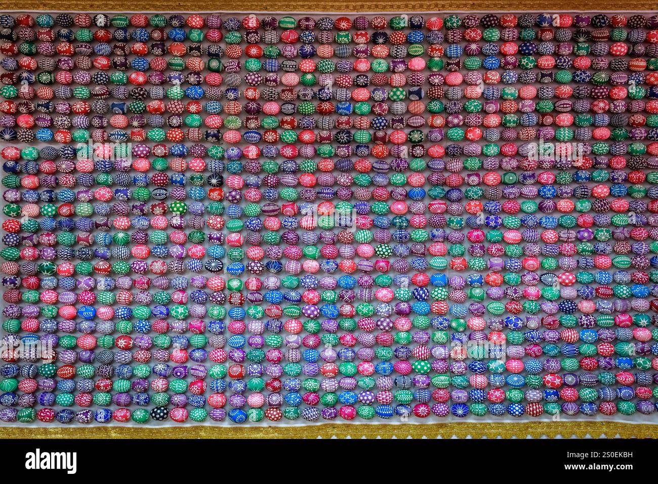 Un mur recouvert de nombreux marbres de différentes couleurs et formes. Les billes sont toutes de tailles et de couleurs différentes, et elles sont disposées de manière à créer Banque D'Images