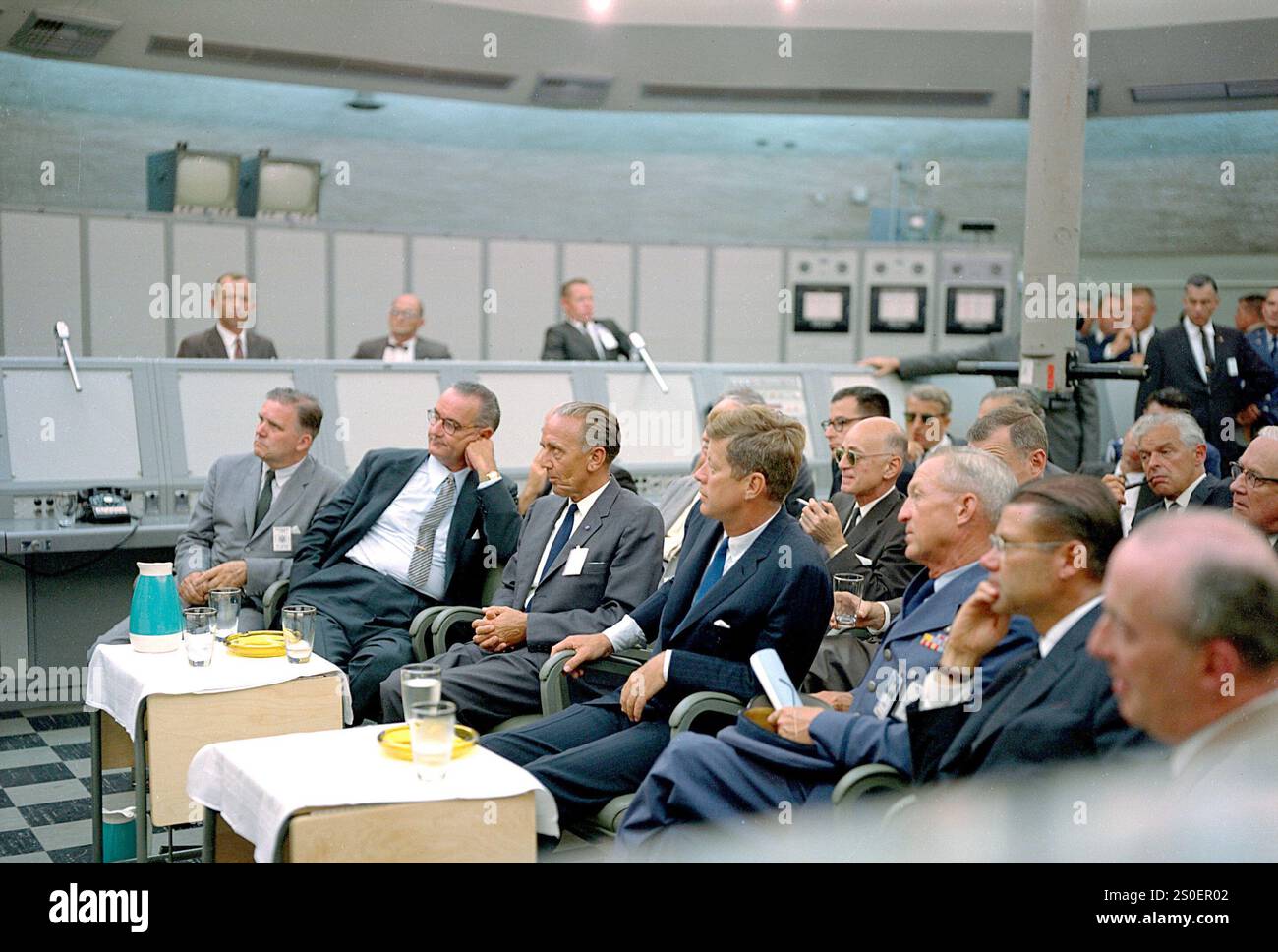 Cap Canaveral, États-Unis, 11 septembre 1962 : le major Rocco Petrone (hors caméra) donne un briefing au président John F. Kennedy lors d'une visite du Blockhouse 34 à l'annexe d'essais de missiles de Cap Canaveral. Sont également présents l'administrateur de la NASA James Webb, le vice-président Lyndon Johnson, le directeur du centre de lancement de la NASA Kurt Heinrich Debus, le secrétaire à la Défense Robert McNamara et d'autres dignitaires. Banque D'Images