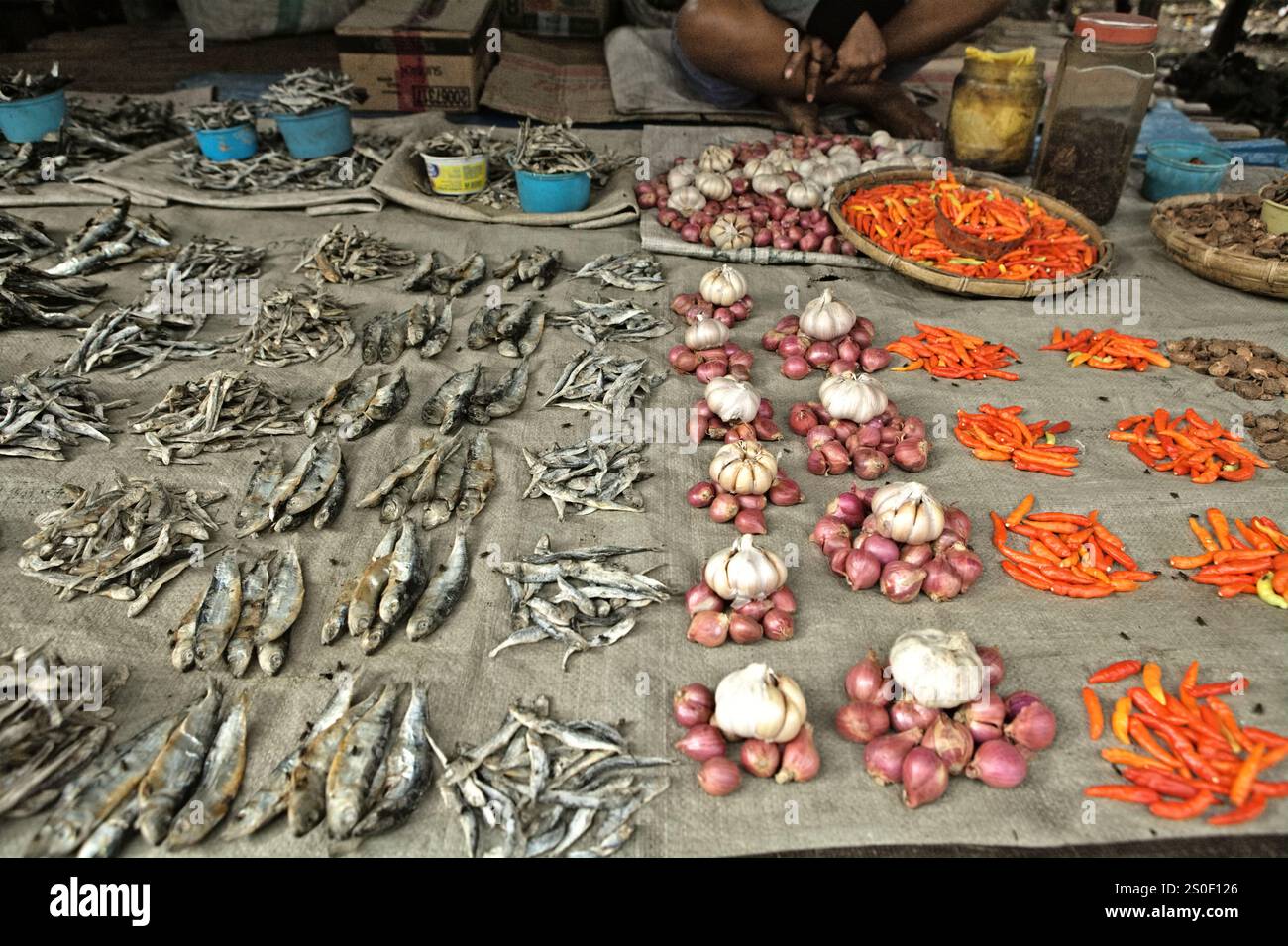 Poissons salés avec des grenades rouges et des piments dans un marché traditionnel à Anakalang, Katikutana, Central Sumba, East Nusa Tenggara, Indonésie. Banque D'Images