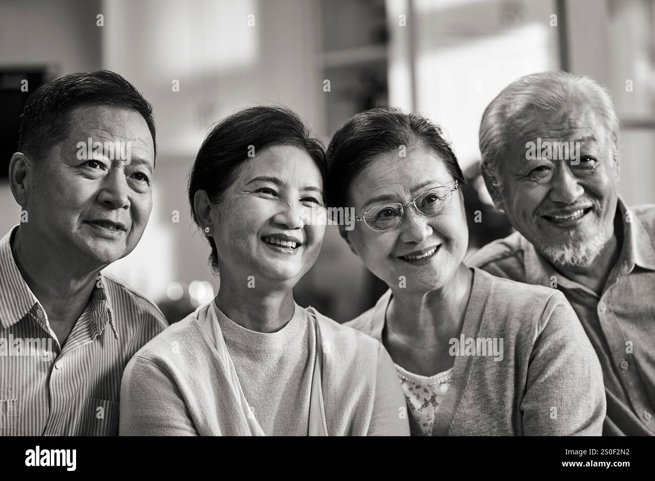 portrait en noir et blanc de deux heureux couples asiatiques seniors regardant la caméra souriante Banque D'Images
