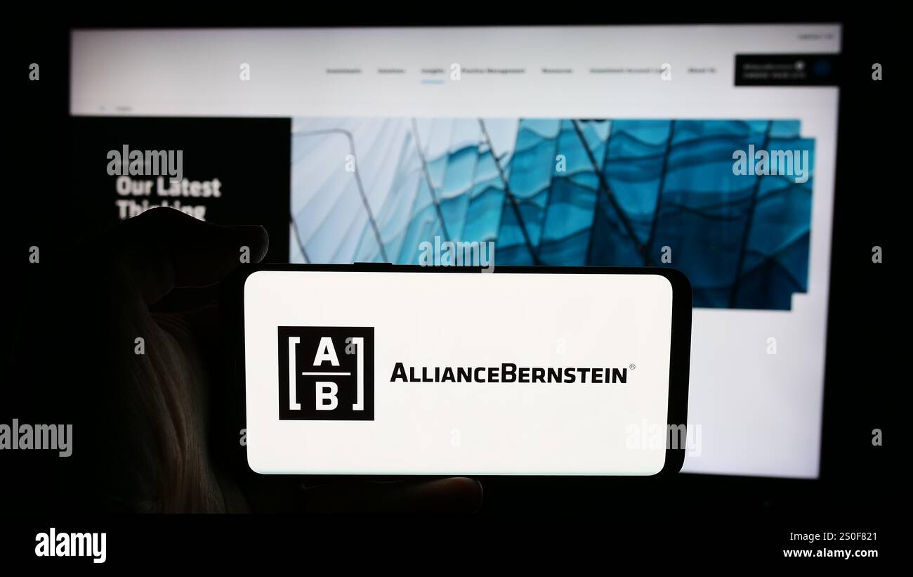 Allemagne. 4 juillet 2024. Dans cette illustration photo, une personne tient un téléphone portable avec le logo de la société d'investissement américaine AllianceBernstein Holding L.P. (AB) devant la page Web. (Crédit image : © timon Schneider/SOPA images via ZUMA Press Wire) USAGE ÉDITORIAL SEULEMENT ! Non destiné à UN USAGE commercial ! Banque D'Images