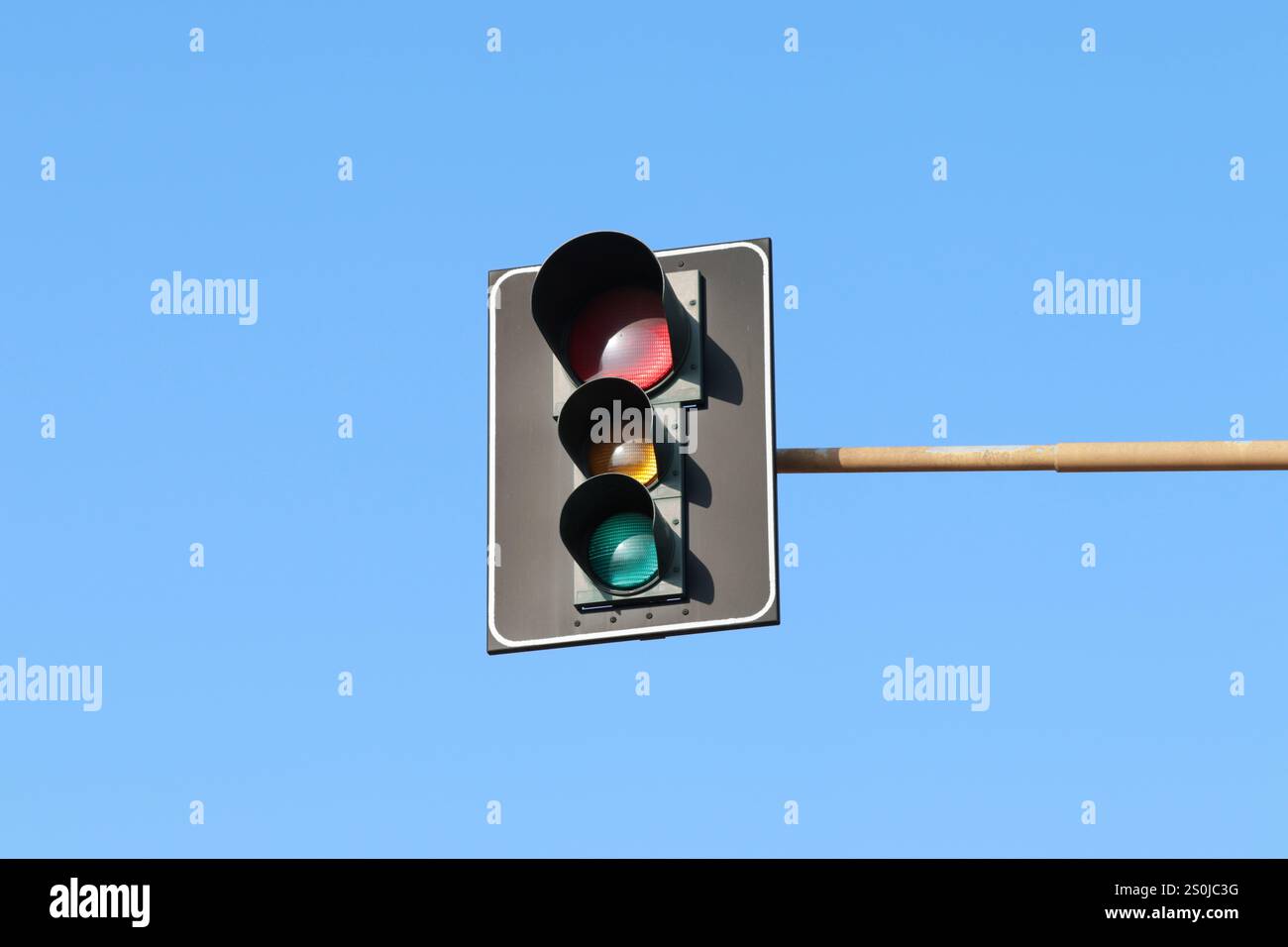 Feu de signalisation avec plaque arrière attachée à un bras, isolé dans le ciel. Banque D'Images