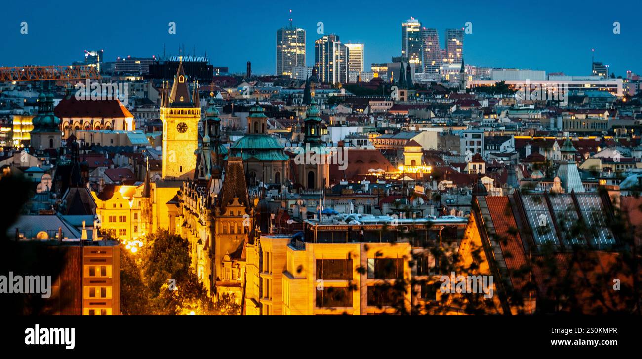 Une vue panoramique sur les gratte-ciel de la ville au crépuscule, mettant en valeur un mélange d'architecture historique et moderne. Le premier plan présente des bâtiments éclairés, tandis que Banque D'Images