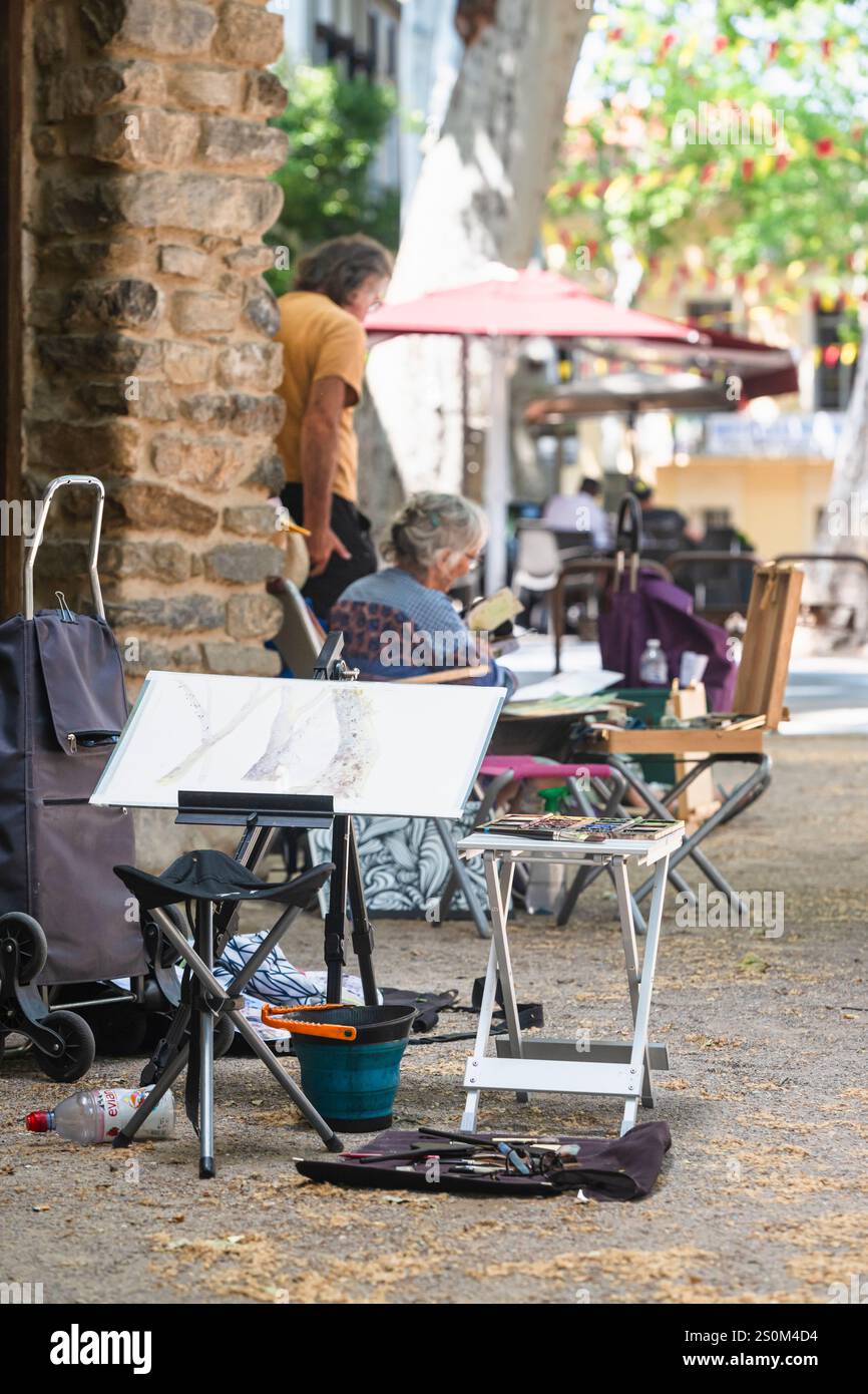 Un groupe d'artistes plus âgés peignent sur la place avec la fontaine de Pablo Picasso dans le centre historique de Cerét, France Banque D'Images