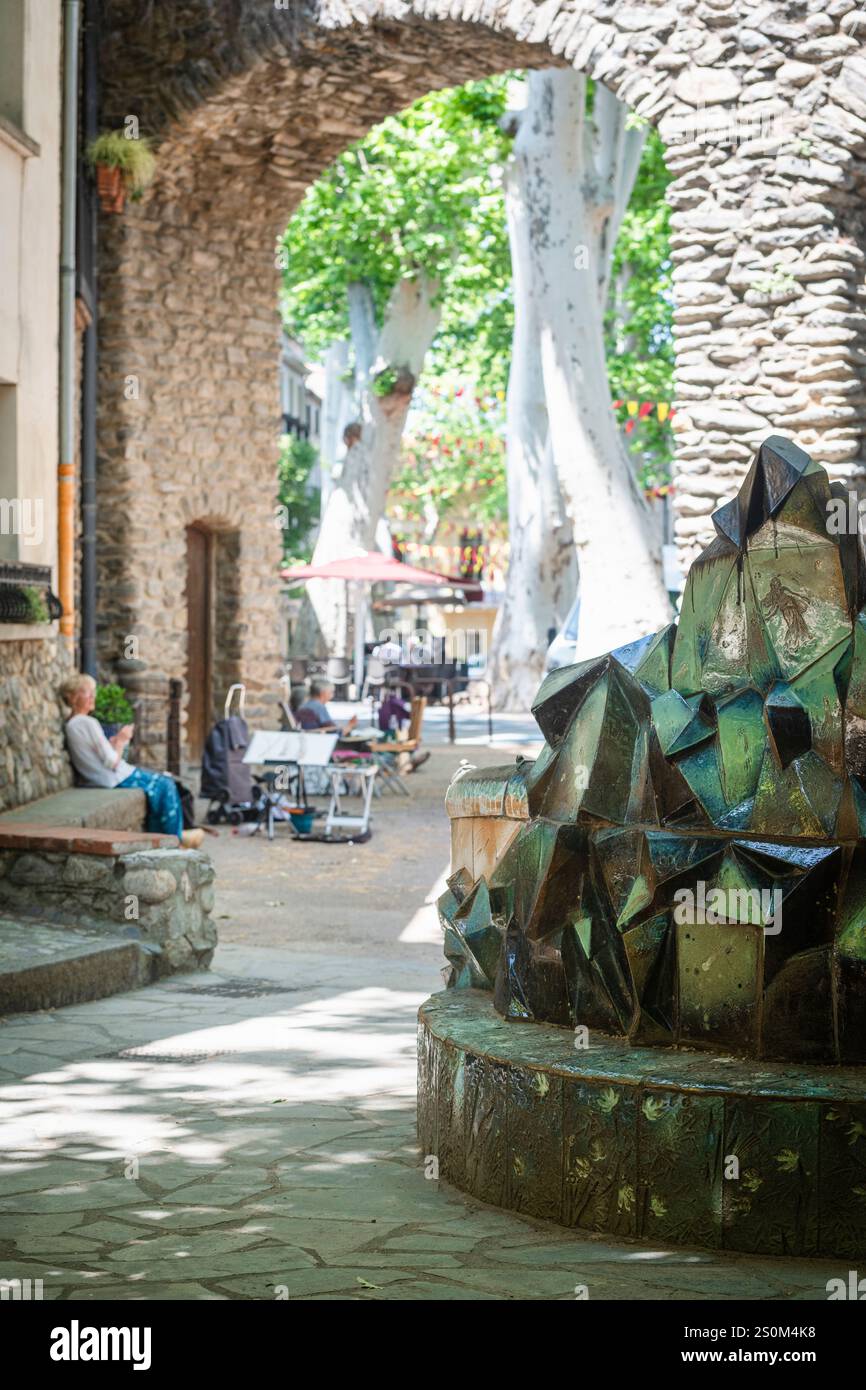 Un groupe d'artistes plus âgés peignent sur la place avec la fontaine de Pablo Picasso dans le centre historique de Cerét, France Banque D'Images