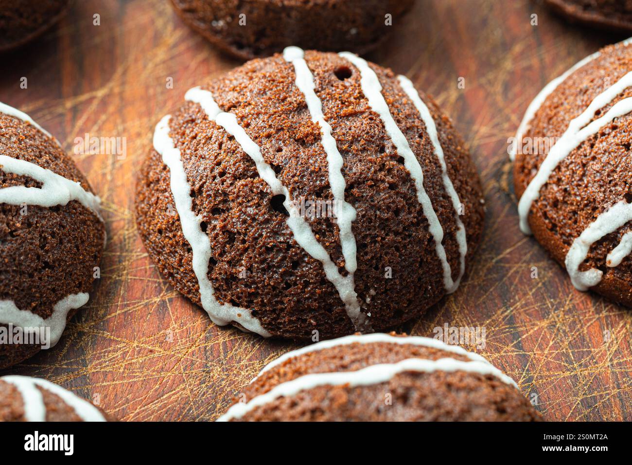 Délicieux biscuits au chocolat décorés de lignes de filet de glaçage blanc sur une planche de bois. Pâtisseries maison. Banque D'Images Délicieux biscuits au chocolat décorés de lignes de filet de glaçage blanc sur une planche de bois. Pâtisseries maison. Banque D'Images