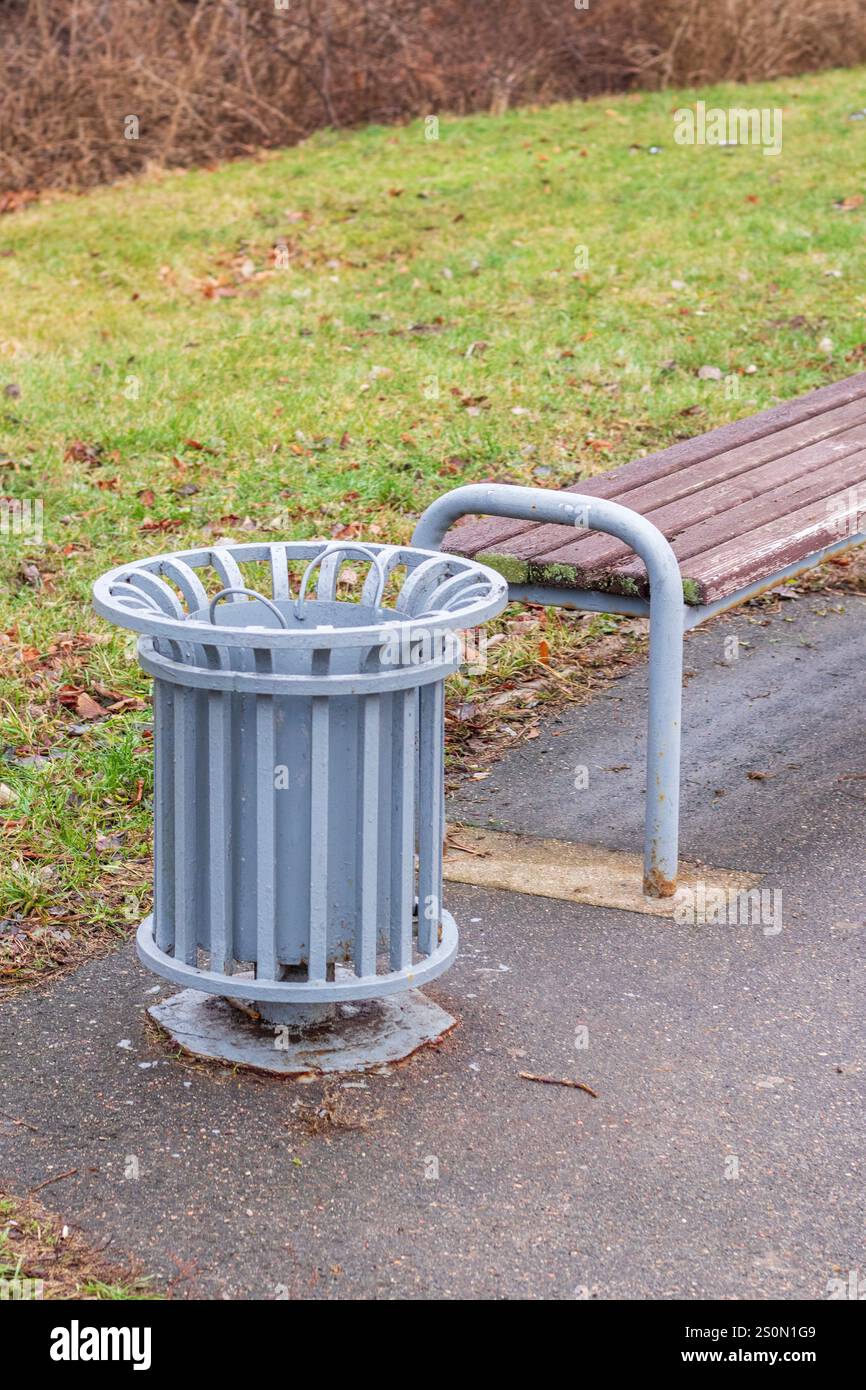 Plan de la poubelle près du banc dans le parc Banque D'Images