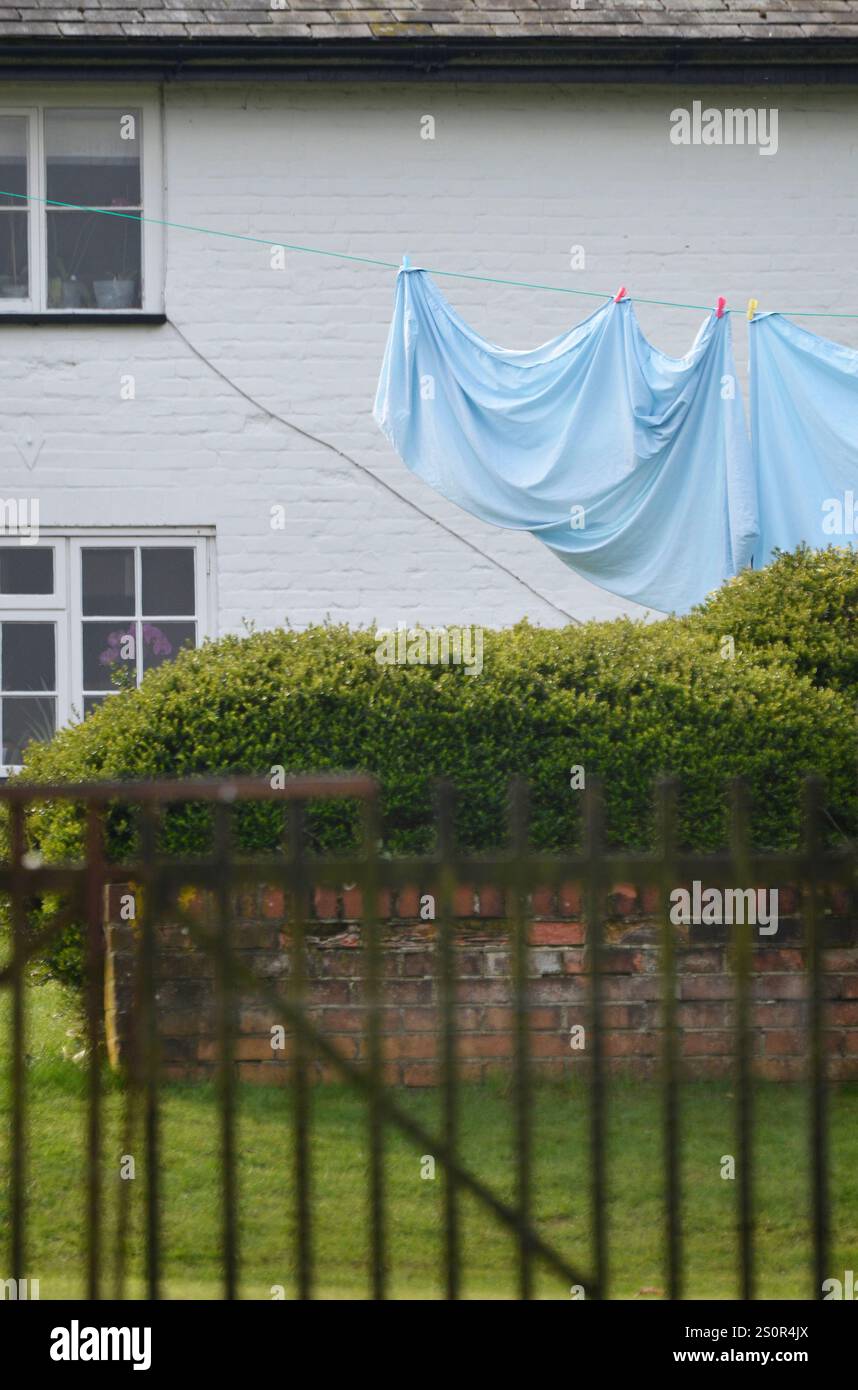 drap de lit accroché sur la ligne de lin à l'extérieur de la maison de ferme rurale, walpole, suffolk, angleterre Banque D'Images