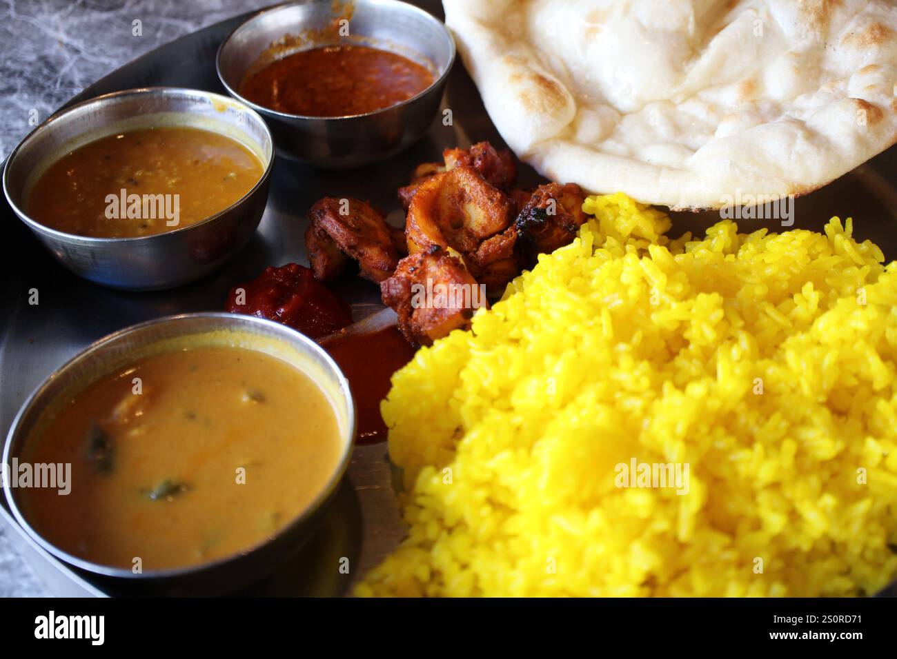 Cuisine indienne : assiette déjeuner au curry (curry au poulet keema, curry aux fruits de mer, curry dal, riz jaune, poulet naan et tandoori) Banque D'Images