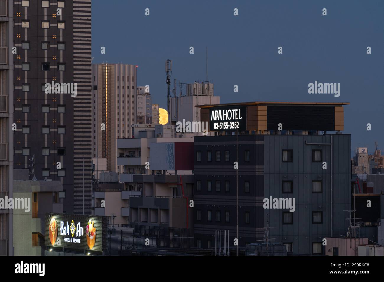 Tokyo, Japon - 15 décembre 2024 - vue de la lune jaune se posant derrière les gratte-ciel de Tokyo, Japon, au lever du soleil tôt le matin Banque D'Images