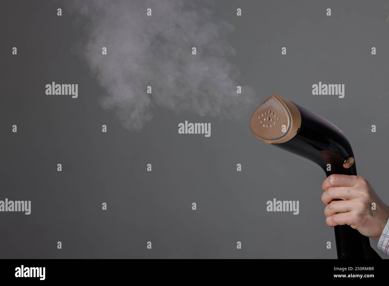 vapeur à main dans la main de la femme avec de la vapeur sur fond gris, gros plan. Banque D'Images