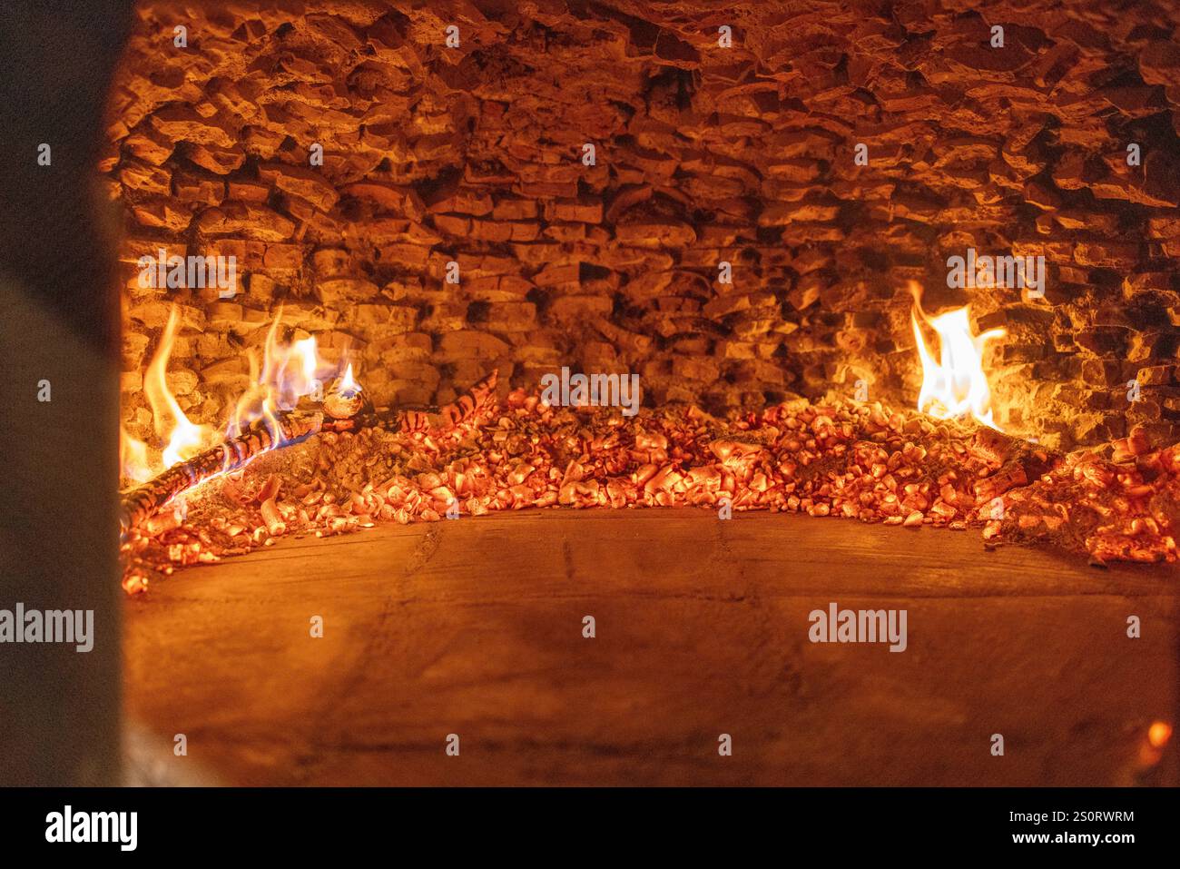 Embers incandescentes et flammes dans un four à bois traditionnel Banque D'Images