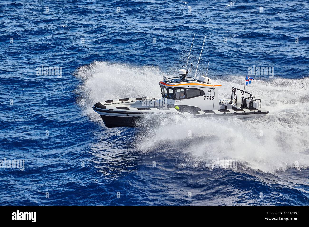Navire maritime à grande vitesse naviguant sur des vagues avec drapeau national affiché Banque D'Images