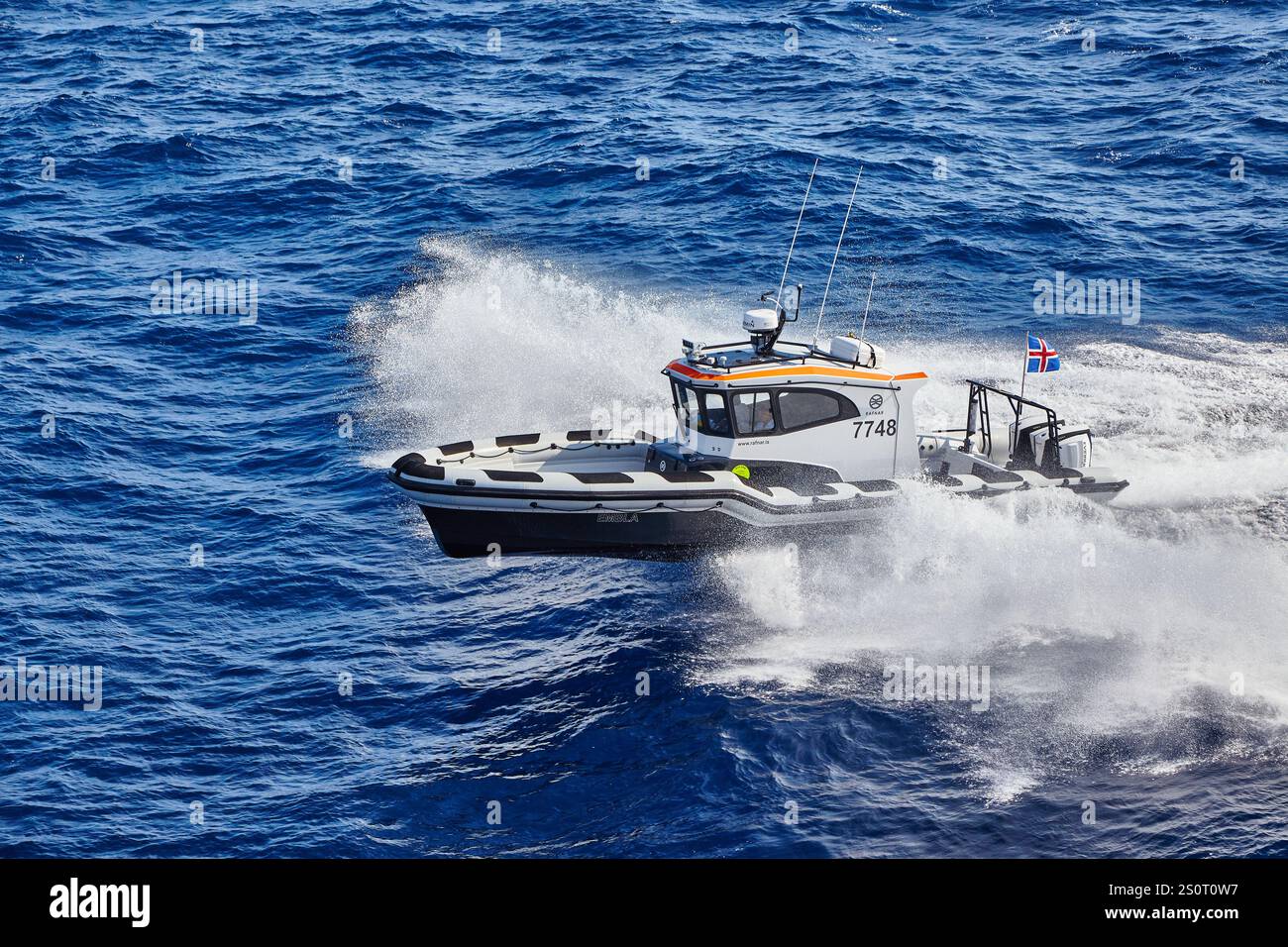 Navire maritime à grande vitesse naviguant sur des vagues avec drapeau national affiché Banque D'Images