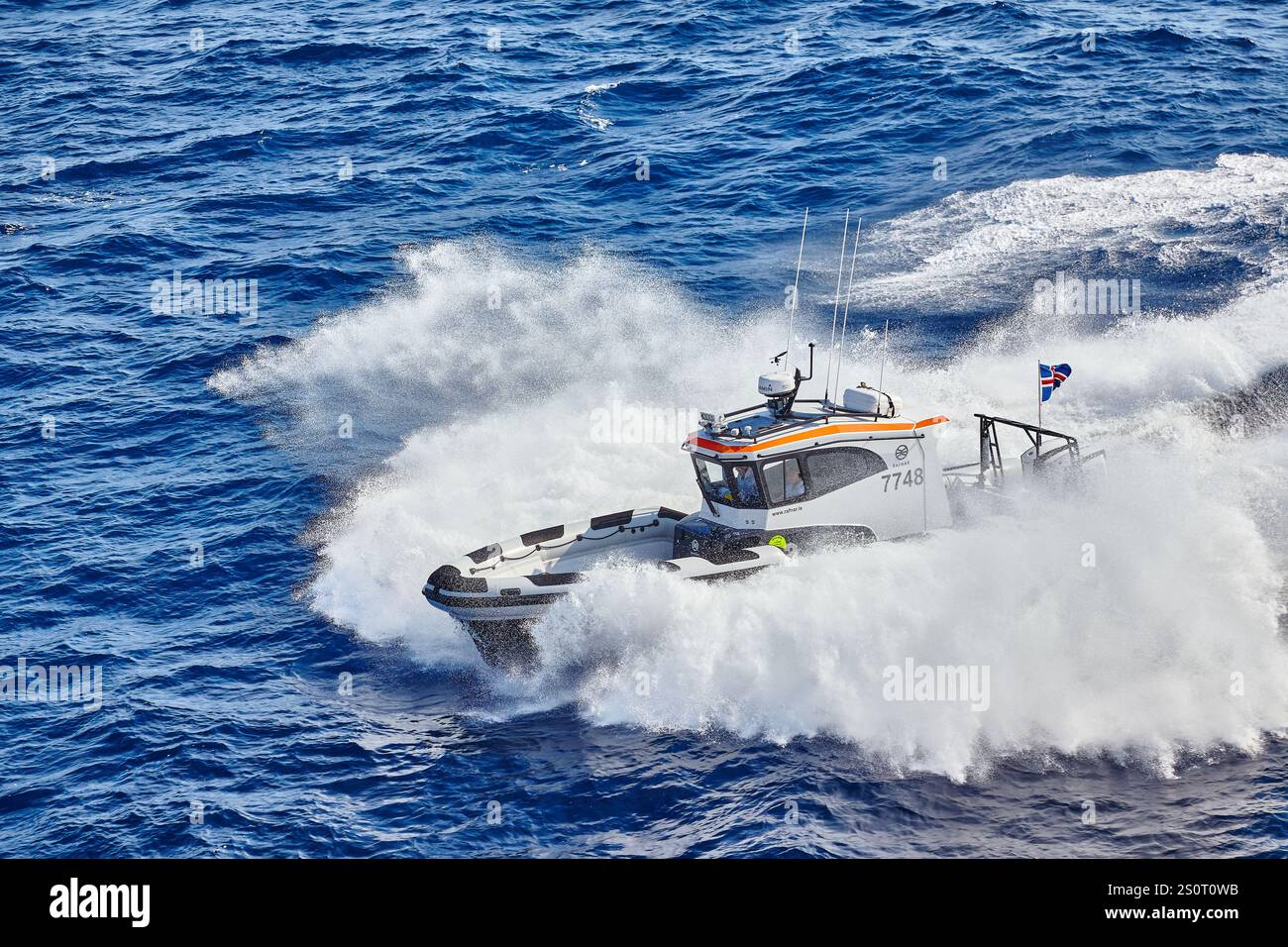 Navire maritime à grande vitesse naviguant sur des vagues avec drapeau national affiché Banque D'Images