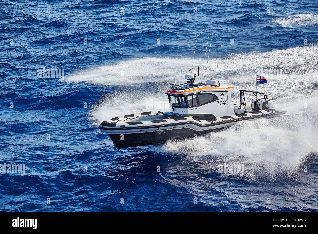 Navire maritime à grande vitesse naviguant sur des vagues avec drapeau national affiché Banque D'Images