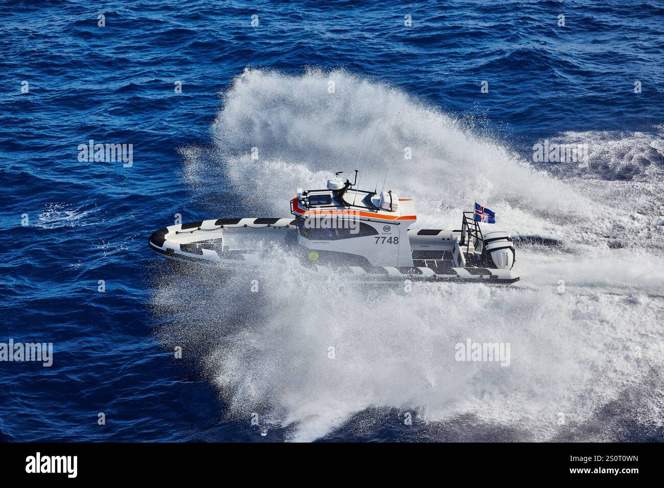 Navire maritime à grande vitesse naviguant sur des vagues avec drapeau national affiché Banque D'Images