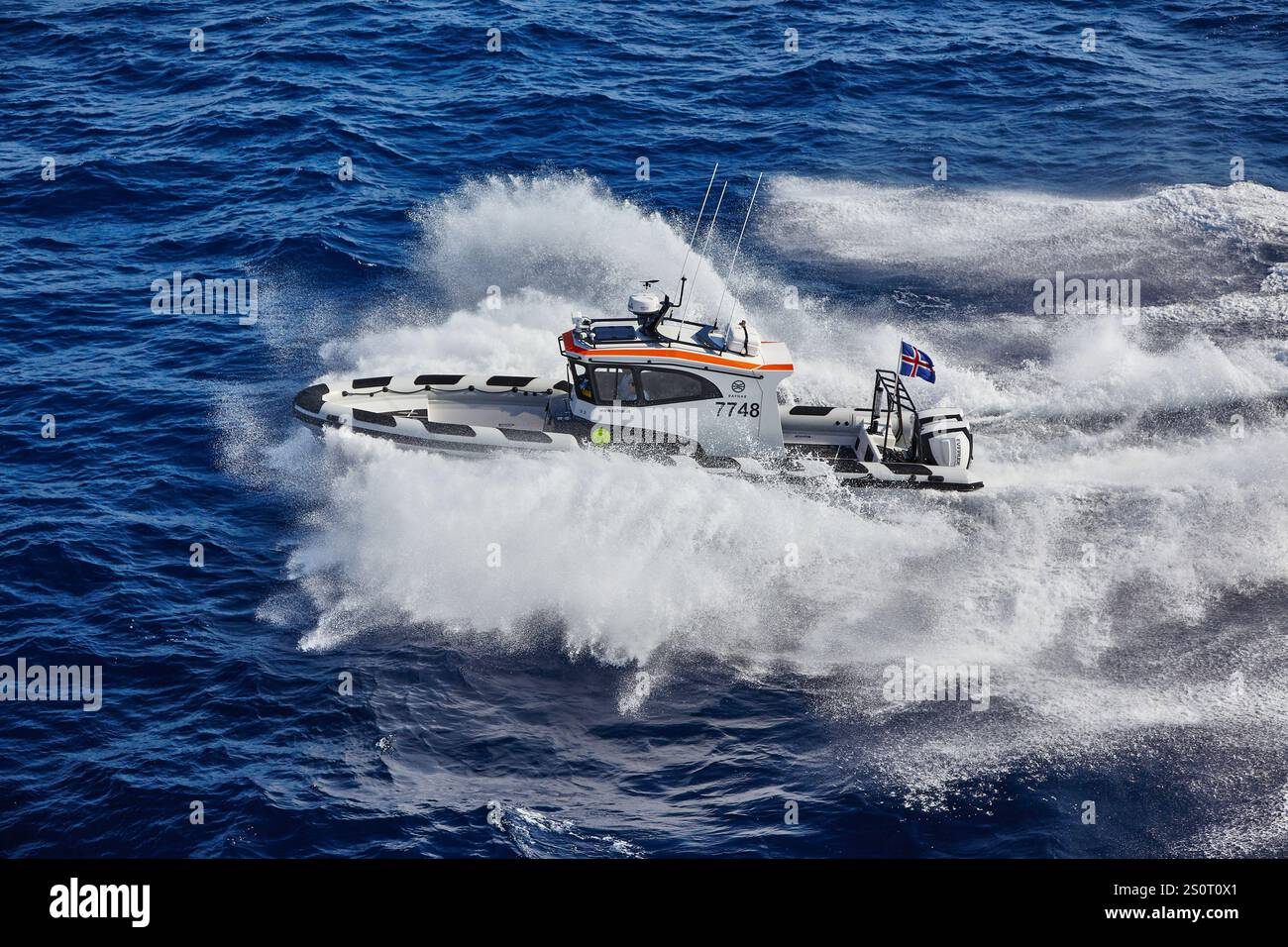 Navire maritime à grande vitesse naviguant sur des vagues avec drapeau national affiché Banque D'Images