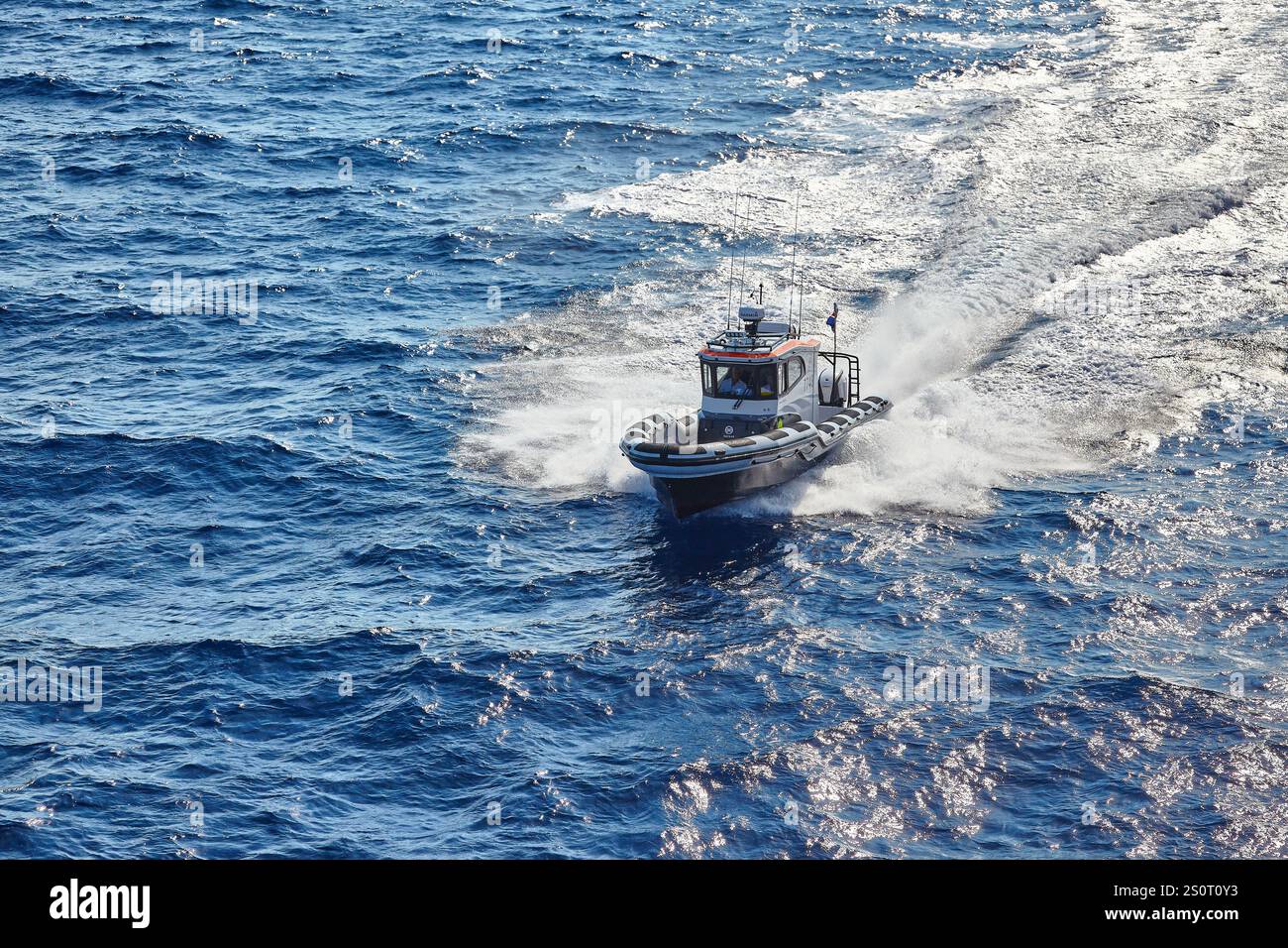 Navire maritime à grande vitesse naviguant sur des vagues avec drapeau national affiché Banque D'Images
