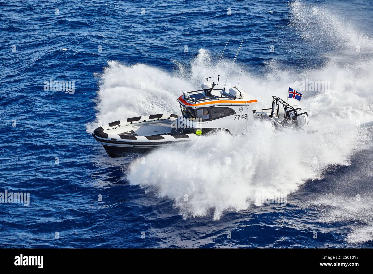 Navire maritime à grande vitesse naviguant sur des vagues avec drapeau national affiché Banque D'Images