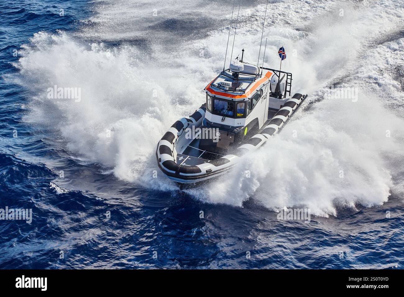 Navire maritime à grande vitesse naviguant sur des vagues avec drapeau national affiché Banque D'Images