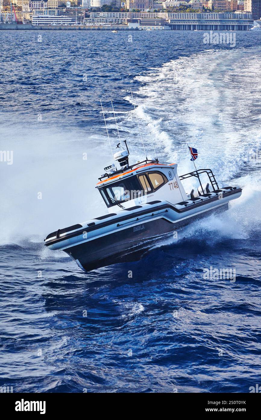 Navire maritime à grande vitesse naviguant sur des vagues avec drapeau national affiché Banque D'Images