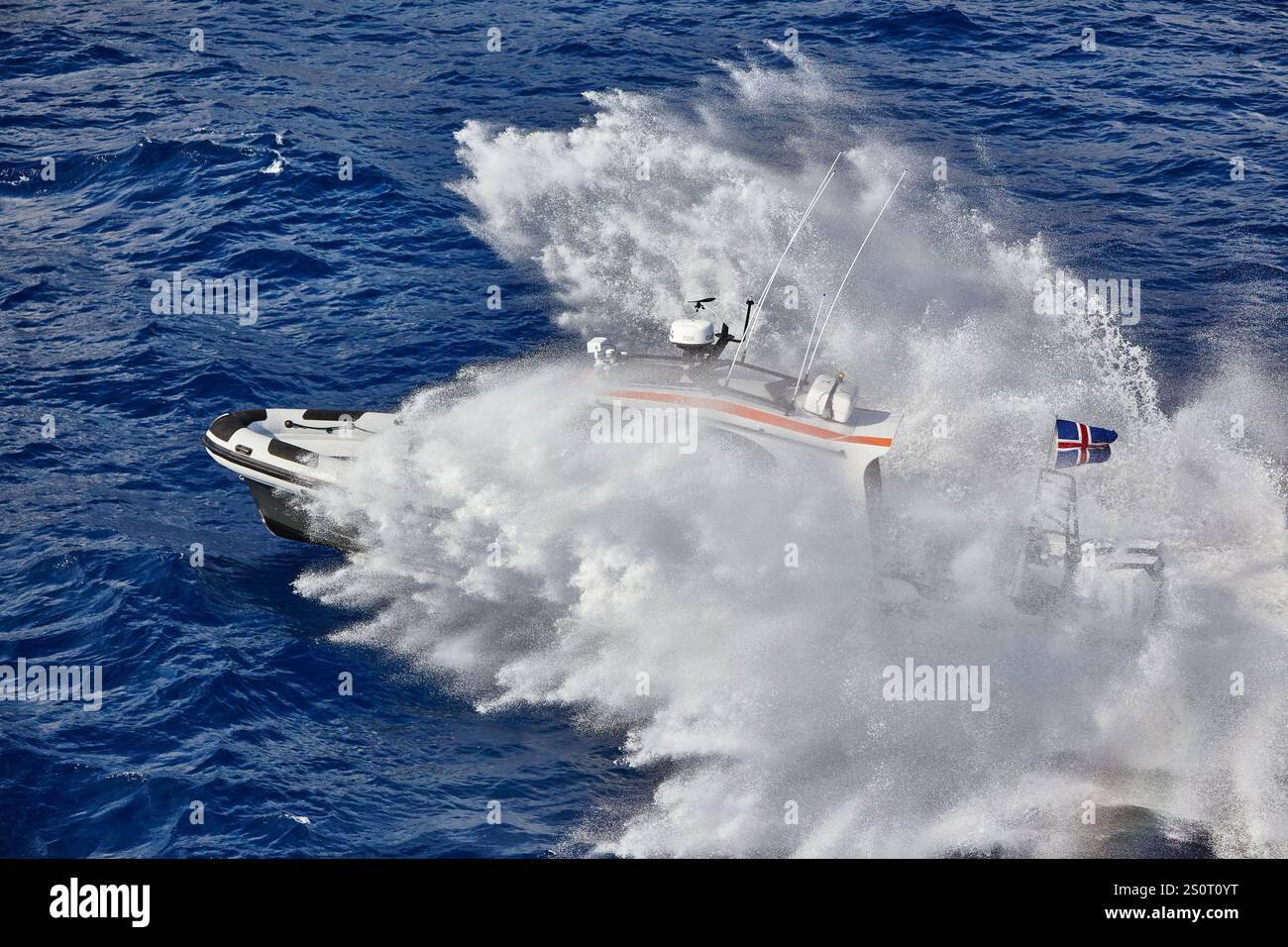 Navire maritime à grande vitesse naviguant sur des vagues avec drapeau national affiché Banque D'Images