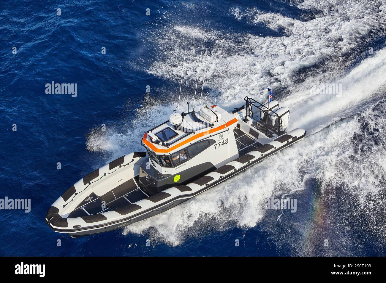 Navire maritime à grande vitesse naviguant sur des vagues avec drapeau national affiché Banque D'Images