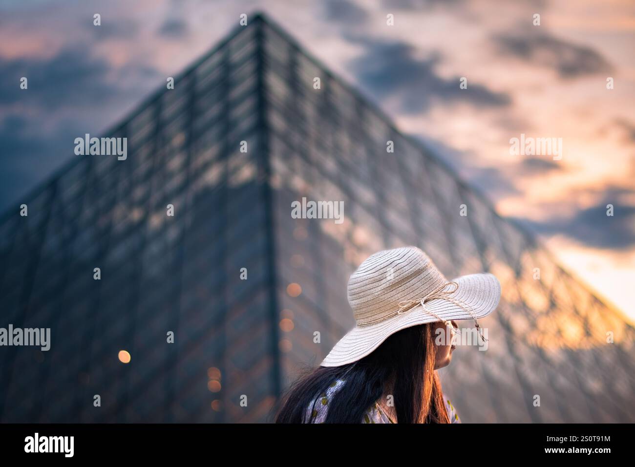 Une belle femme devant le musée du Louvre, l'un des plus grands musées du monde et un monument historique. Un point de repère central de Paris, France. Banque D'Images