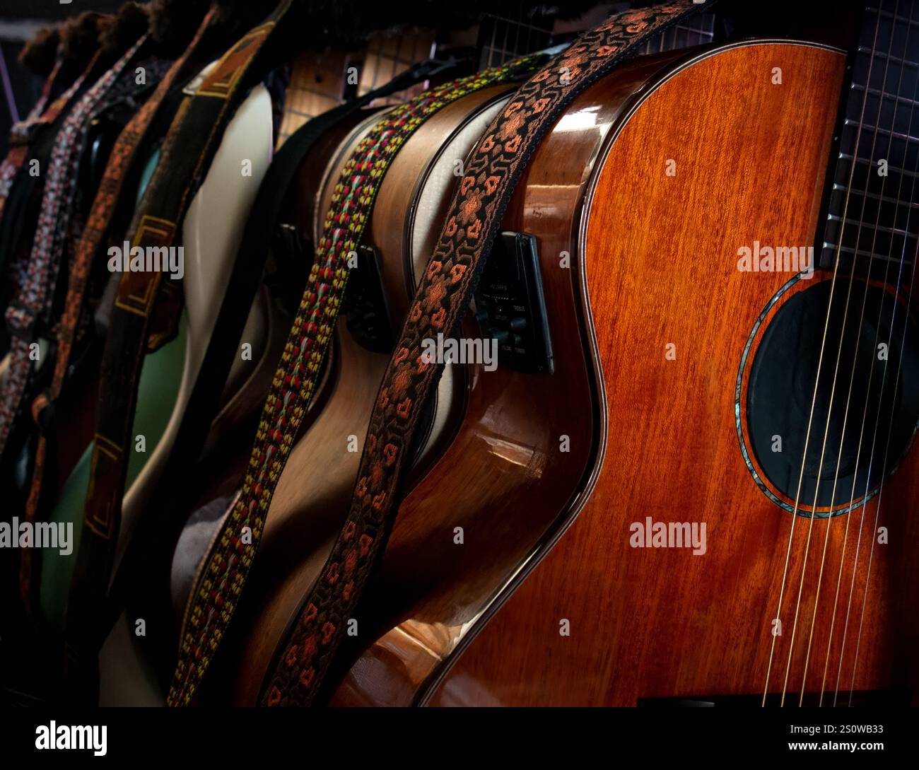 Guitares - de nombreuses guitares acoustiques, basses et électriques sur support de guitare se tiennent dans les coulisses d'une salle de concert ou dans un studio d'enregistrement. Banque D'Images