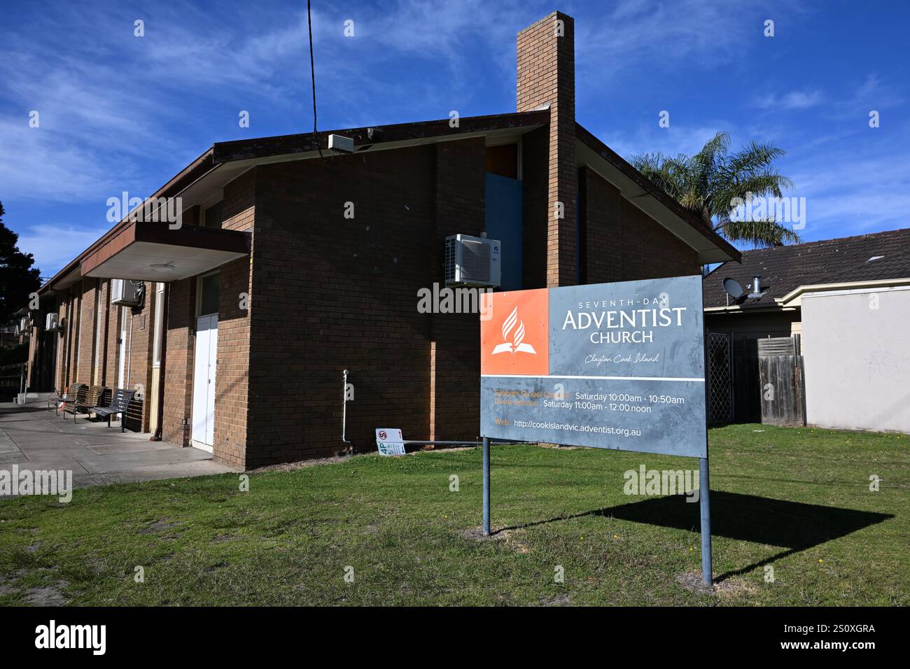 Extérieur de l'église adventiste du septième jour de l'île de Cook, avec une signalisation contemporaine de style chrétien protestant gris et orange devant le bâtiment Banque D'Images