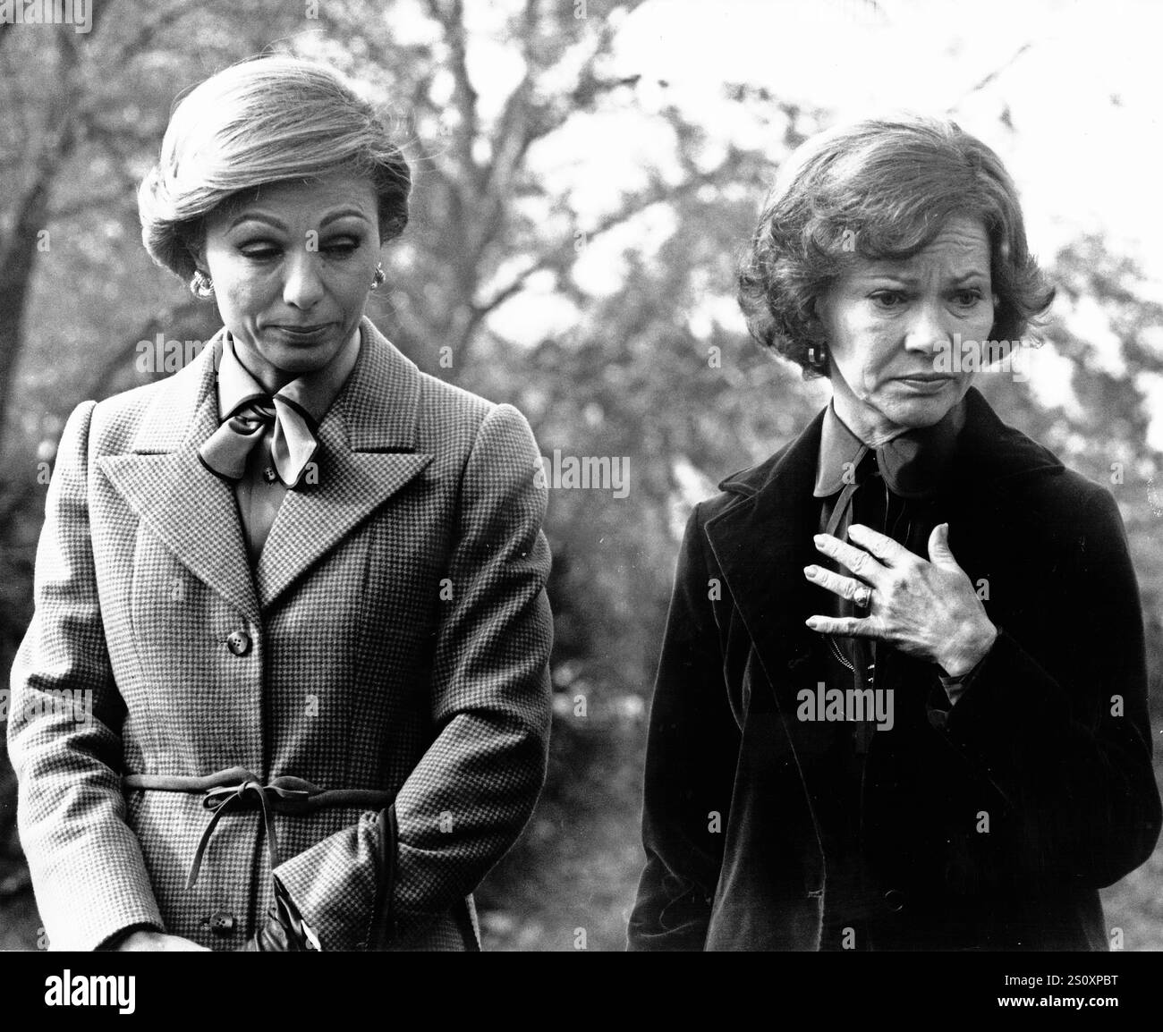 La première dame Rosalynn carter, à droite, et Farah Diba Pahlavi, la Shahbanu d'Iran, à gauche, combattent les larmes alors que des gaz lacrymogènes utilisés par la police pour disperser une perturbation protestant contre la visite du Shah d'Iran ont dérivé sur le terrain de la Maison Blanche lors de la cérémonie d'arrivée d'État à Washington, DC le 15 novembre 1977. Crédit : Benjamin E. “Gene” forte/CNP Banque D'Images